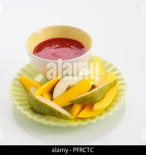 Fette di pera e mango con frutta Lampone dip Foto Stock