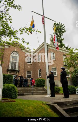 BREMERTON, nello Stato di Washington (28 maggio 2018) della Cmdr. Brian Rednour, delegato, Base Navale Kitsap, saluta mentre in piedi con i marinai e i membri della famiglia di Boatswain Mate 3° di classe Desirae Stern e aviazione di Boatswain Mate (attrezzature) Airman Rosa Reynoso, entrambi assegnati alla Base Navale di Kitsap funerali divisione, sollevare il ensign nazionale durante un giorno memoriale della cerimonia sulla base navale Kitsap-Bremerton. Riconosciuto l'ultimo lunedì di maggio Memorial Day è osservata in onore di coloro che hanno dato la loro vita in difesa degli Stati Uniti. Foto Stock