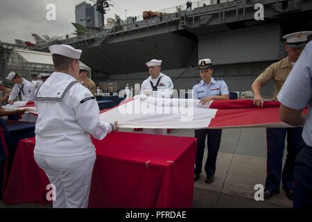 Stati Uniti Marines, marinai, Costa guardie e soldati distendere la bandiera americana durante la Intrepid Giorno Memoriale della commemorazione a Intrepid Sea, Air & Space Museum di New York, 28 maggio 2018. Marines, marinai e la costa guardie sono a New York per interagire con il pubblico e dimostrare le funzionalità avanzate e insegnare alla gente di New York circa l'America servizi marittimi. Foto Stock