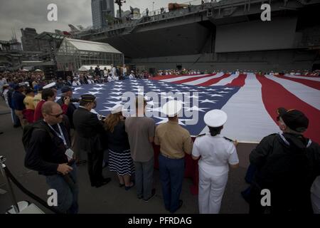 Stati Uniti Marines, marinai, Costa guardie, soldati e veterani militari ne spiegherà la bandiera americana durante la Intrepid Giorno Memoriale della commemorazione a Intrepid Sea, Air & Space Museum di New York, 28 maggio 2018. Marines, marinai e la costa guardie sono a New York per interagire con il pubblico e dimostrare le funzionalità avanzate e insegnare alla gente di New York circa l'America servizi marittimi. Foto Stock