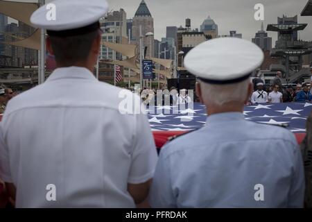 Stati Uniti Marines, marinai, Costa guardie, soldati e veterani militari ne spiegherà la bandiera americana durante la Intrepid Giorno Memoriale della commemorazione a Intrepid Sea, Air & Space Museum di New York, 28 maggio 2018. Marines, marinai e la costa guardie sono a New York per interagire con il pubblico e dimostrare le funzionalità avanzate e insegnare alla gente di New York circa l'America servizi marittimi. Foto Stock