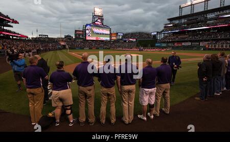 2018 del Dipartimento della Difesa giochi guerriero atleti prendere parte all'inno nazionale presso la Colorado Rockies Memorial Day Gioco a Denver in Colorado, 28 maggio 2018. Il DoD Warrior giochi sono un evento annuale, istituito nel 2010, per introdurre feriti e ammalati e feriti i membri del servizio di adaptive lo sport come un modo per migliorare il loro recupero e riabilitazione. Foto Stock