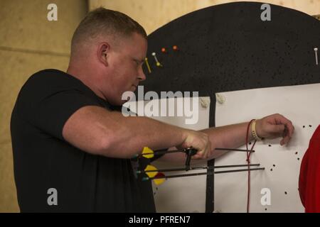 Stati Uniti Marine Corps Staff Sgt. Michael a piedi nudi recupera le sue frecce durante un 2018 DoD Warrior Giochi per la pratica del tiro con l'arco a Cheyenne Mountain High School in Colorado Springs, Colo., 25 maggio 2018. Il guerriero giochi è adattativa di competizione sportiva per i feriti e ammalati e feriti i membri del servizio e i veterani. Foto Stock