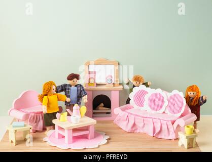 Casa delle Bambole della famiglia in soggiorno con verde pallido a parete e pavimento in legno Foto Stock