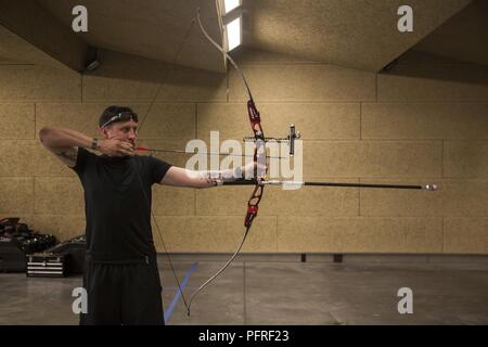 Stati Uniti Marine Corps Staff Sgt. Jason Pacheco trae la sua prua durante un 2018 DoD Warrior Giochi per la pratica del tiro con l'arco a Cheyenne Mountain High School in Colorado Springs, Colo., 26 maggio 2018. Il guerriero giochi è adattativa di competizione sportiva per i feriti e ammalati e feriti i membri del servizio e i veterani. Foto Stock