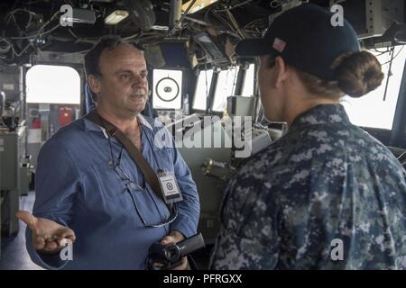 Della caldera di Santorini, Grecia (24 maggio 2018) - Il Sig. Dimitris Prassos del vulcano di Santorini TV parla con Ensign Nichole Roden, public affairs officer del guidato-missili cruiser USS Normandia (CG 60), nel corso di un tour a sostegno di una programmata visita porta. La Normandia è attualmente implementato come parte di Harry Truman Carrier Strike gruppo. Foto Stock