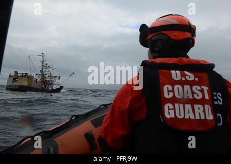 Petty Officer di terza classe Popeck Cameron, un team di imbarco timoniere per la USCGC Mellon (WHEC 717), si avvicina alla nave da pesca stella polare per distribuire un team di imbarco per far rispettare le leggi e i regolamenti relativi al settore della pesca degli Stati Uniti nel mare di Bering, 30 maggio 2018. Il Mellon equipaggio condotto la pesca commerciale imbarco nave durante un Alaskan patrol. Stati Uniti Coast Guard Foto Stock