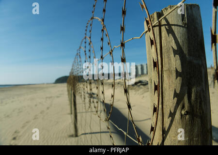 Durban, KwaZulu-Natal, Sud Africa, weathered recinto sulla spiaggia dove il filo spinato è ombra di colata su legno fencepost, paesaggio, città Foto Stock