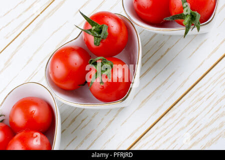 Rosso ciliegia matura di pomodori Pomodori nel cuore ciotola sagomata Foto Stock