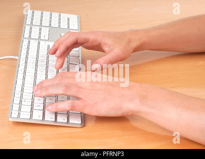 Mani digitando su una tastiera di computer, close-up Foto Stock