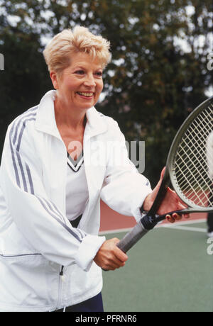 Donna che mantiene una racchetta da tennis Foto Stock