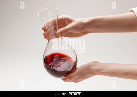 Agitando il vino rosso in decanter, close-up Foto Stock