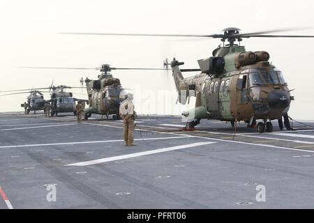 Golfo Arabico, Kuwait - UH-60 Black Hawk elicotteri assegnato al primo battaglione, 244Reggimento di aviazione (assalto), 449th combattere la Brigata Aerea terra a bordo della più grande nave da guerra spagnola mai costruito per la Spagna, LHD Juan Carlos I (L-61), nel Golfo Arabico, 23 maggio 2018. La loro missione è stato quello di escort l'esercito spagnolo unità di aviazione, Task Force Toro, Cougar elicotteri a Camp Buehring, il Kuwait come una posizione preliminare prima di volare a Camp Taji, in Iraq a sostegno di funzionamento inerenti risolvere ove essi forniranno il carico e il trasporto del personale. Foto Stock