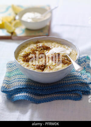 Chorba al-adas, spessa zuppa di lenticchie cosparso con cipolle fritte e cucchiaiata di yogurt Foto Stock