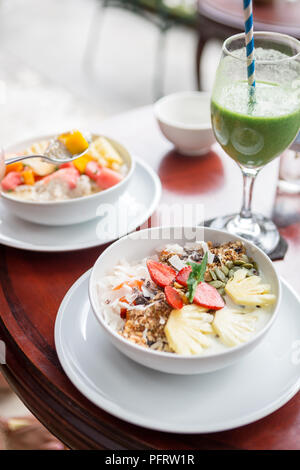 Gustosa e salutare porridge di fiocchi d'avena con frutta, bacche, ananas, fragole e semi di lino. Mangiare sano concetto di stile di vita. La cura per la salute e la bellezza. H Foto Stock