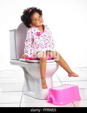 Il Toddler ragazza sul wc, 2 anni Foto Stock