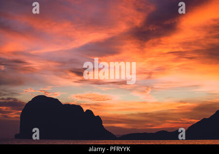 Isole tropicali tramonto; insolito isola thailandese al bellissimo e drammatico tramonto. Forma dell'isola appare come una persona che stabilisce. Foto Stock