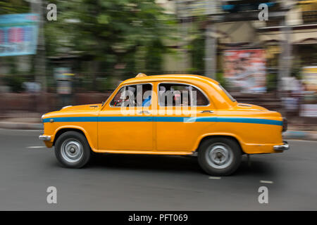 Il giallo indiano Ambasciatore taxi guida su strade di Calcutta, in India Foto Stock