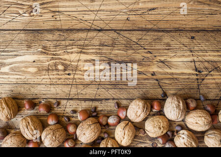 Le noci, le nocciole e cedro al buio su un sfondo di legno vecchio. Noce sana nutrizione. Foto Stock