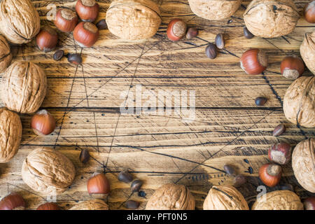 Le noci, le nocciole e cedro al buio su un sfondo di legno vecchio. Noce sana nutrizione. Foto Stock