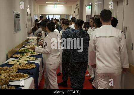 Stati Uniti I membri del servizio si raccolgono intorno ad un tavolo di ristoro durante la grande apertura di Robert M. Casey navale ramo della famiglia Clinica Iwakuni al Marine Corps Air Station Iwakuni, Giappone, 30 maggio 2018. Il personale ha ospitato la grande apertura al fine di visualizzare la struttura di funzionalità nuove e migliorate. Foto Stock