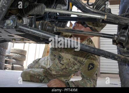 Un Texas guardie dal 3° Battaglione 133Campo reggimento di artiglieria, El Paso, sulla distribuzione per il presidio delle dogane e della protezione delle frontiere Pattuglia di Confine stazione su Stati Uniti/Messico frontiera richiede uno sguardo più da vicino alla parte inferiore di un ATV durante una manutenzione di routine controllare, 23 maggio. Spc. Daniel Almodovar e le altre guardie a sostegno della missione di ottenere 'more badges torna alla frontiera' fare un impatto tangibile ogni volta a prendere uno dei non-esecuzione agenti di posizioni, tipicamente, otterrete informazioni dettagliate su off la linea a che fare, come il fleet, manutenzione e le armi o le mansioni amministrative. Foto Stock