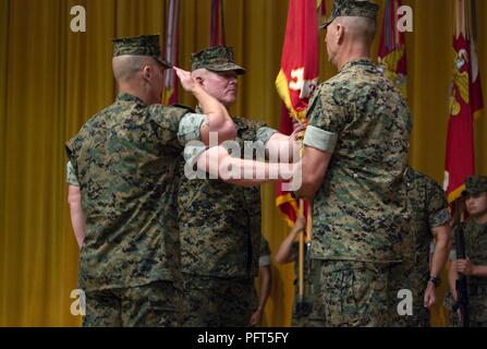 Brig. Gen. Daniel B. Conley, centro, in uscita comandante generale della terza Marine Logistics Group, passa la terza MLG colori per Col. Ronald C. Braney, incoming comandante della terza MLG, durante il trasferimento del comando cerimonia il 1 giugno 2018 presso il Camp Foster, Okinawa, in Giappone. Il passaggio dei colori simboleggia il trasferimento ufficiale dell'unità da un comandante al successivo. Conley è un nativo di Falmouth, Massachusetts. Braney è un nativo di Manlius, New York. Foto Stock