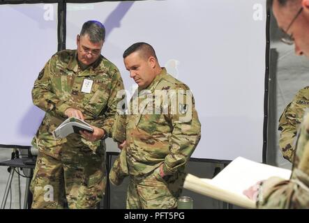 Il comandante del xxi Theatre Supporto comando, il Mag. Gen. Steven A. Shapiro e Briga. Gen. Clint E. Walker, commander, 184supporto comando guardare oltre le note prima di un briefing operazioni inizia il 31 maggio in Powdiz, Polonia durante lo sciopero di Saber 18. La partecipazione in esercizi di multinazionali quali Saber Strike migliora le nostre relazioni professionali e migliora il coordinamento generale con gli alleati e con le forze armate di partner durante i periodi di crisi. (Mississippi Guardia Nazionale Foto Stock