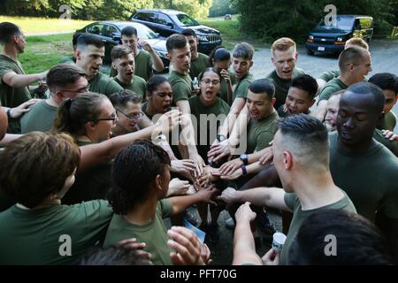 Stati Uniti Marines assegnati alle varie combattere le unità di telecamera intorno alla regione della capitale nazionale mettere le loro mani insieme per onorare caduti Marines con un canto motivati a seguito della conclusione di un memoriale di girare al Marine Corps Corps base Quantico, Va., 25 maggio 2018. Il memorial run è stato trattenuto per commemorare i caduti della fotocamera di combattimento Marines, con interventi motivati nonché brioso esecuzione di cadenze dalla corrente della telecamera di combattimento Marines di stanza nella regione della capitale nazionale. Foto Stock