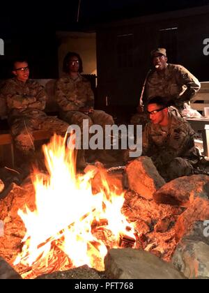 Soldati con truppe speciali battaglione, terza divisione di fanteria sostegno deciso supporto la brigata di sedersi intorno a un falò mentre mangiando s'more durante un singolo soldato forum di Bagram Airfield, Afghanistan, 29 maggio. I soldati hanno discusso le relazioni e le sfide di essere unico in campo militare. Foto Stock