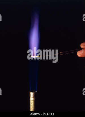Esperimento di fiamma azienda composto di potassio sul filo di platino nel becco Bunsen fiamma, girando la fiamma viola Foto Stock