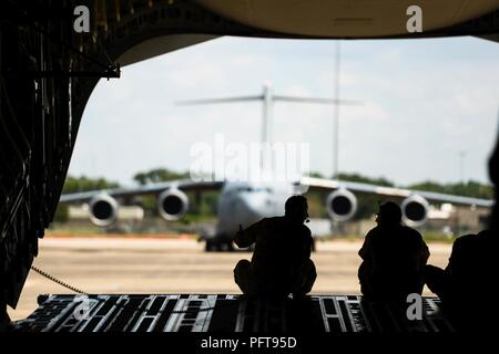 Da sinistra a destra, U.S. Air Force Staff Sgt. Randall Moss, Master Sgt. Justin Mulder e Senior Airman Lucas Randolph sedersi sulla rampa del loro C-17 Globmaster III come essi e altri aeromobili da base comune Charleston, Carolina del Sud, parco di Fort Polk, Louisiana, e preparare per caricare paracadutisti DA PARTE DEGLI STATI UNITI Esercito 509a del Reggimento di Fanteria, 22 maggio 2018. Circa 15 C-17 Globemaster III aeromobile da base comune Charleston forniscono supporto airdrop per gli Stati Uniti Esercito 509a del Reggimento di Fanteria, Fort Polk, Louisiana, come parte integrante di una grande disponibilità di formazione esercizio, aria scenda parat Foto Stock