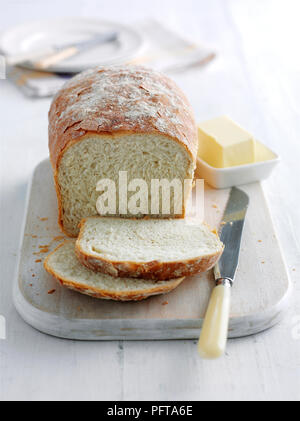 Agriturismo focaccia con alcune fette tagliate, Coltello per pane e burro nelle vicinanze Foto Stock