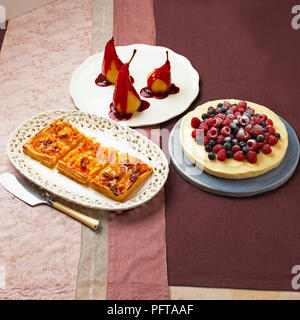 Raccolta di dessert, albicocca e mandorla galette, pere in camicia con salsa di blackberry, Cheesecake al limone guarnita con frutti di bosco freschi Foto Stock