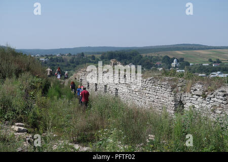 I partecipanti dell'agenzia di tour ROOTKA specializzata in tour del patrimonio ebraico nell'Europa orientale camminano tra le rovine della fortezza del castello nella città di Sataniv, che un tempo era sede di una grande comunità ebraica e fu annientata, brutalmente, dai tedeschi durante la seconda guerra mondiale nel Raion di Horodok, Khmelnytskyi Oblast, Ucraina. Foto Stock