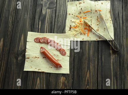 Salsiccia casalinga con pane pita su sfondo di legno Foto Stock