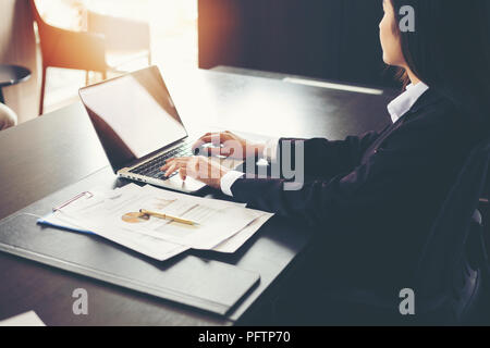 Asian imprenditrici utilizzando computer portatili documenti di analisi e grafico schema finanziario su office di lavoro del tavolo Foto Stock