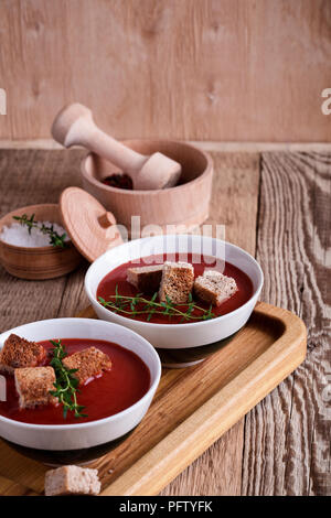 Tradizionale zuppa di pomodoro guarnita con pane di segale di crostini e timo Foto Stock