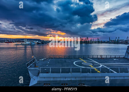 Parte della fregata, un atterraggio in elicottero al tramonto nel porto. nave militare. Le forze di marina Foto Stock