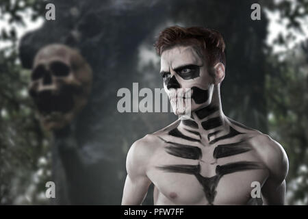 Il dia de los Muerto Costume - il giorno dei morti è una vacanza messicana. Qui è un uomo con il cranio e la faccia contro lo sfondo della terribile foresta e th Foto Stock