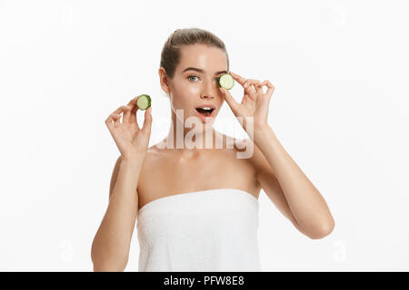 Giovani belle, donna felice è in possesso di alcuni cetriolo davanti al suo volto sorridente. Isolato su sfondo bianco. Foto Stock