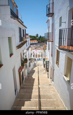 Passeggiando per le fasi di una stretta strada spagnolo di bianco Case Murate in Mijas, Andalusia nel sud della Spagna Foto Stock