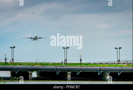 Il passeggero aereo decolla in aeroporto con un bellissimo cielo blu e nuvole. Lasciando il volo. Iniziare il viaggio all'estero. Tempo di vacanza. Riga e cella solare Foto Stock