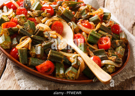 Un sano pasto dietetico okra con pomodoro e cipolla close-up su una piastra sul tavolo orizzontale. Foto Stock