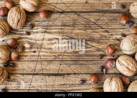 Le noci, le nocciole e cedro al buio su un sfondo di legno vecchio. Noce sana nutrizione. Foto Stock