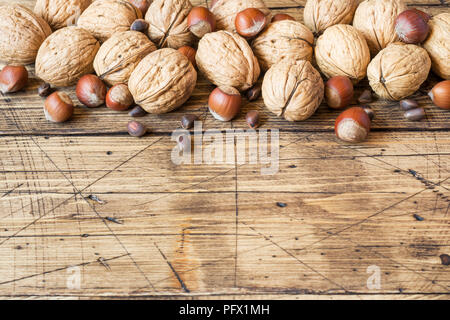 Le noci, le nocciole e cedro al buio su un sfondo di legno vecchio. Noce sana nutrizione. Foto Stock