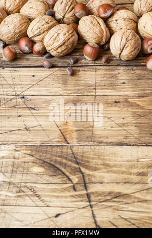 Le noci, le nocciole e cedro al buio su un sfondo di legno vecchio. Noce sana nutrizione. Foto Stock