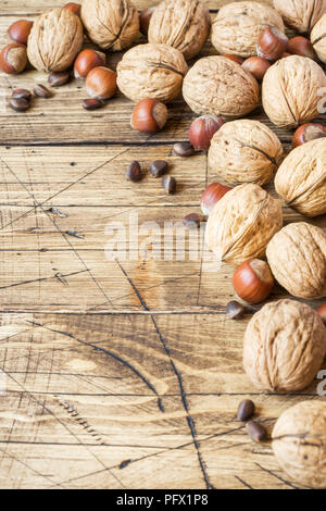 Le noci, le nocciole e cedro al buio su un sfondo di legno vecchio. Noce sana nutrizione. Foto Stock