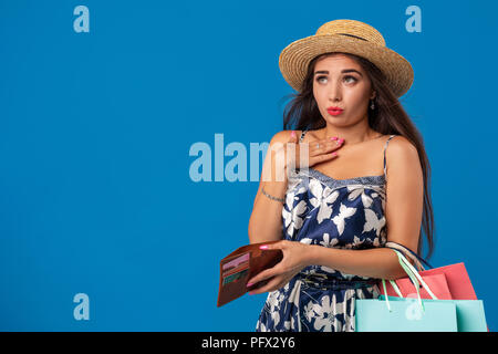 Ritratto di infelice giovane donna cerca nel suo portafoglio nel centro commerciale, trascorso troppo, non abbastanza denaro, denaro perso, rotto Foto Stock