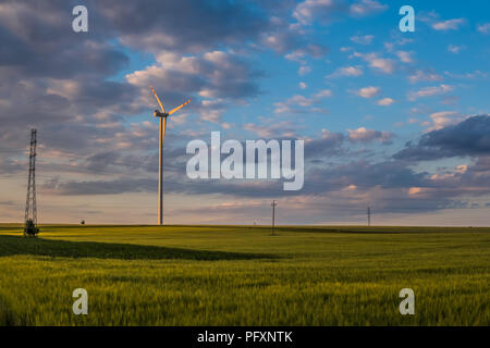 Blu cielo con cirro cumulus nubi sul paesaggio rurale con i campi e la turbina eolica Foto Stock